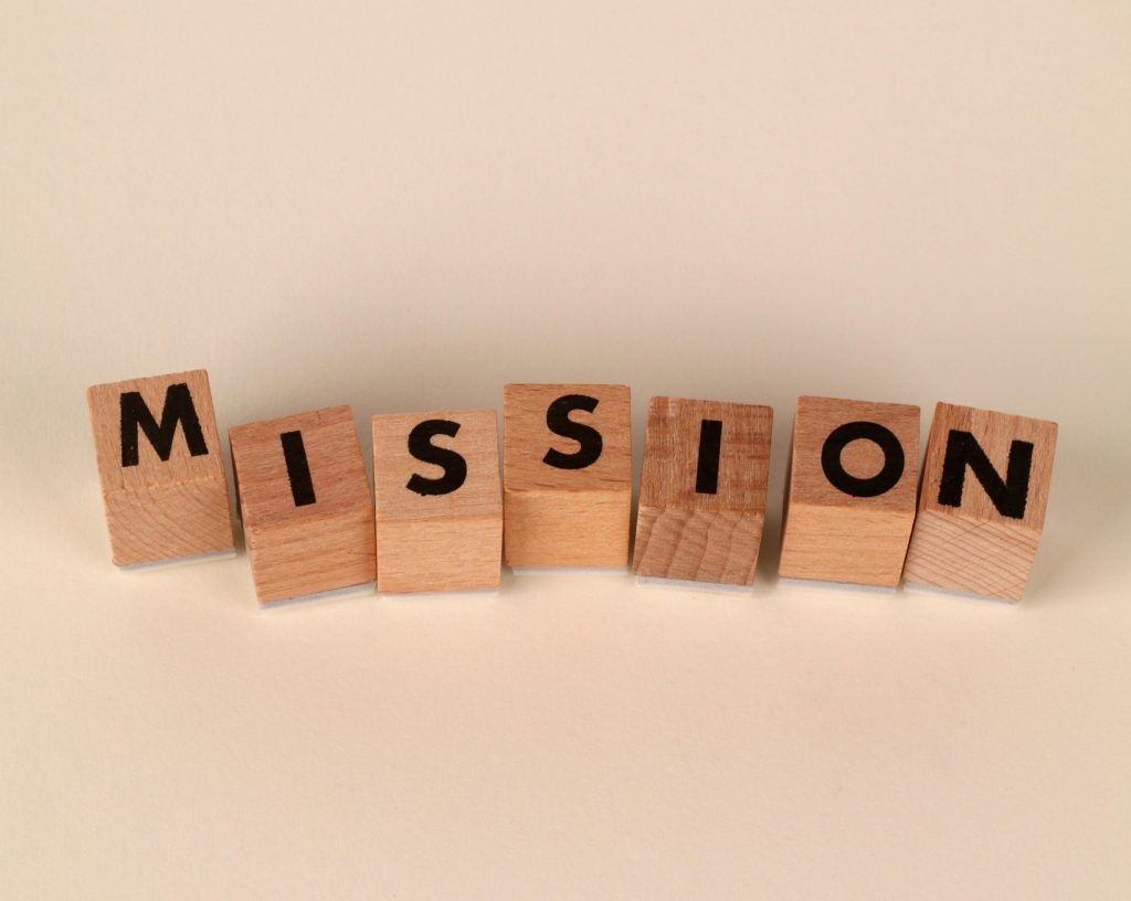 Wooden blocks with letters spelling 'Mission' on a soft neutral background, ideal for business themes.